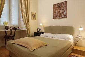 a bedroom with a bed and a chair and a window at Residenza Le 6 A in Trieste