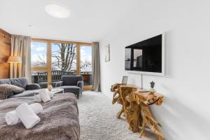 a living room with two beds and a flat screen tv at Casa Hirsch - Zentral, Bergblick, TV, Nespresso in Miesbach