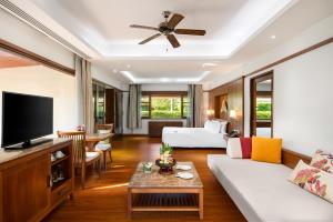 a living room with a couch and a tv at Santiburi Koh Samui in Mae Nam