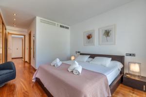 a bedroom with a large bed with towels on it at Apartment La Nau - Fantastic Apartment with hot tub and pool, just steps away from beach in Port de Pollensa +29 photos