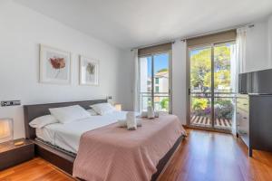 a bedroom with a bed and a large window at Apartment La Nau - Fantastic Apartment with hot tub and pool, just steps away from beach in Port de Pollensa