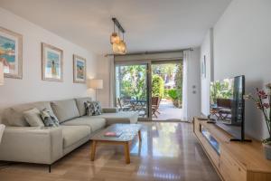 a living room with a couch and a table at Apartment La Nau - Fantastic Apartment with hot tub and pool, just steps away from beach in Port de Pollensa