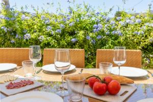 a table with wine glasses and tomatoes on it at Apartment La Nau - Fantastic Apartment with hot tub and pool, just steps away from beach in Port de Pollensa