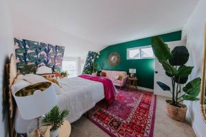 1 dormitorio con cama y pared verde en Pink Paradise Inn - 5 BR Fun Retro Home w/ Pool, en Oceanside