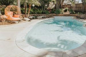 una piscina de agua azul en un patio en Pink Paradise Inn - 5 BR Fun Retro Home w/ Pool, en Oceanside