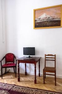 a desk with two chairs and a computer monitor on it at Gutsa Artists Mini-Hotel in Tbilisi City