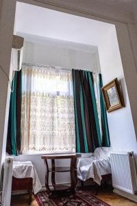 Habitación con ventana, cama y mesa. en Gutsa Artists Mini-Hotel en Tiflis