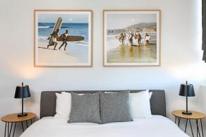 a bedroom with three pictures of people on the beach at Element on Coolum Beach in Coolum Beach