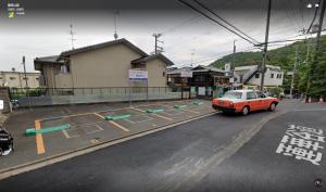 um carro laranja estacionado ao lado de uma rua em 京町家一棟貸しKyoto Machiya Stay En em Quioto