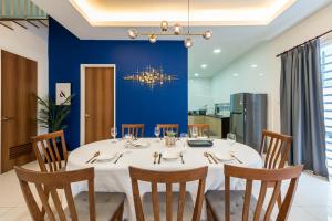 un comedor con una mesa blanca y una pared azul en 5Bedroom Villa @ Seremban 20pax Netflix Projector Pool, en Seremban