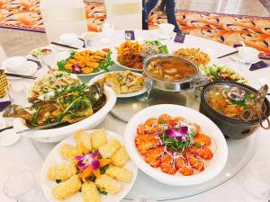 a table with plates of food and bowls of food at Viktor Legends Hotel in Móng Cái