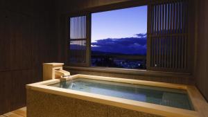 jacuzzi en una habitación con ventana en Yoshidaya Sannoukaku, en Kaga