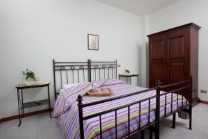 CavrianaにあるBed & Breakfast Conca Verdeのベッドルーム1室(ベッド1台付)、木製キャビネットが備わります。