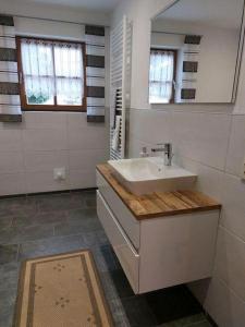 a white bathroom with a sink and a mirror at Ferienhof Altmann in Arrach