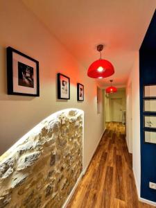un couloir avec un mur en pierre et deux lumières rouges dans l'établissement Ultimate escape from Luxembourg, à Arlon