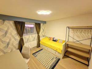 - une petite chambre avec un lit jaune et une fenêtre dans l'établissement Ultimate escape from Luxembourg, à Arlon