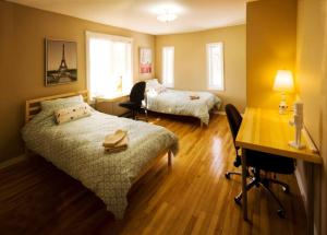 a hotel room with two beds and a desk and a desk at 4 bedroom 4parking can cook Fireplace,Office in Ottawa