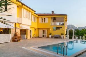 a villa with a swimming pool in front of a house at APA Mountain Lodge in Antalya