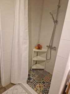 baño con ducha y suelo de baldosa. en Petite maison chaleureuse avec parking, en Leuze-en-Hainaut