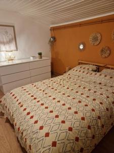 a bedroom with a bed with a quilt on it at Petite maison chaleureuse avec parking in Leuze-en-Hainaut