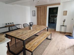 uma mesa de madeira e cadeiras numa sala de estar em Petite maison chaleureuse avec parking em Leuze-en-Hainaut