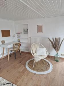 a living room with a chair and a table at Petite maison chaleureuse avec parking in Leuze-en-Hainaut