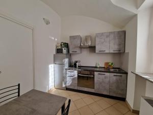cocina con paredes blancas y electrodomésticos de acero inoxidable en Il Fiocco Dla Duja di Ciriè, en Cirié