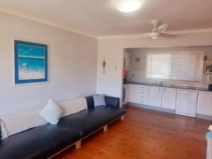a living room with a couch and a kitchen at Watts @ Callala Beach-Pet Friendly in Callala Beach