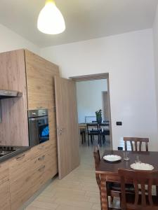 una cucina con tavolo e una sala da pranzo di KRIS87 A 5 Minuti dal Porto ad Alghero