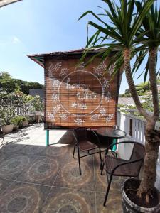 a sign on a wall with a table and chairs at INNI Homestay in Malang