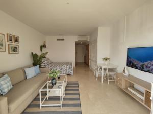 a living room with a couch and a flat screen tv at Estudio Puerto de Sotogrande in San Roque