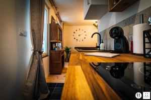 a kitchen with a counter and a clock on the wall at Haut 30 in Saint-Amand-les-Eaux