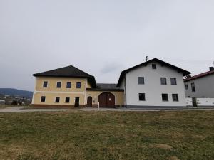 a large white house with a large yard at Ferdlhof Ferienwohnung in Ulrichsberg