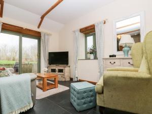 een woonkamer met een bank en een tv bij Beech Cottage in Truro