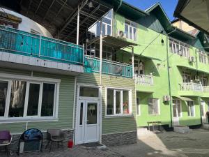 a green building with a balcony on top of it at OSH ART Meergul in Osh