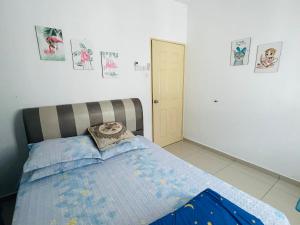 a bedroom with a bed with a pillow on it at NO 121 NAZIRIN HOMESTAY TMN DESA MANJUNG in Lumut