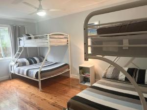 a room with two bunk beds and a window at Watts @ Callala Beach-Pet Friendly in Callala Beach