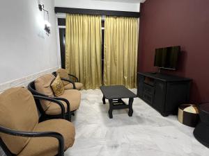 a living room with two chairs and a television at Glory Beach Resort Beach View in Port Dickson