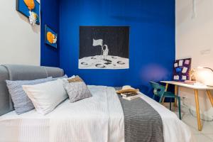 a bedroom with a bed with a blue wall at 5Bedroom Villa @ Seremban 20pax Netflix Projector Pool in Seremban +54 photos