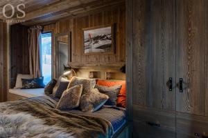 um quarto com uma cama grande e paredes de madeira em Nydelig og Moderne hytte på Kikut Geilo - 6 senger, 4 soverom og jacuzzi em Geilo