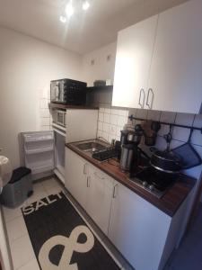 a small kitchen with white cabinets and a counter top at Ferienwohnung Lüttje Delftblick in Emden