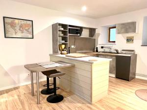 a kitchen with a counter and a table in it at Gîte de campagne Gaspard in Macornay +5 photos