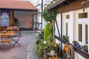 un patio al aire libre con mesas, sillas y plantas en Landhotel Kahltalmühle en Alzenau in Unterfranken