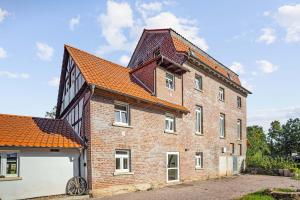 een groot bakstenen gebouw met een oranje dak bij Landhotel Kahltalmühle in Alzenau in Unterfranken