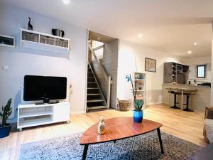 sala de estar con TV de pantalla plana y mesa en Gîte de campagne Gaspard, 