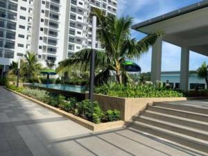 a resort with a pool and palm trees and a building at Traders Garden , cheras Trader square 3 bedroom Balakong serdang in Cheras