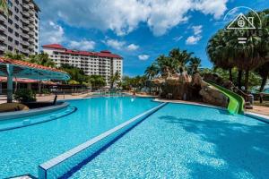 a large swimming pool at a resort with a slide at Glory Beach Resort Beach View in Port Dickson