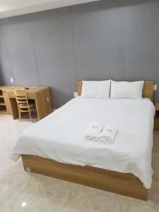 a bedroom with a large bed with two towels on it at ZEN BUILDING in Ho Chi Minh City