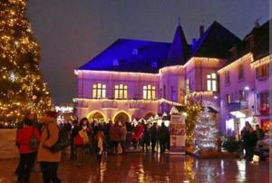 um grupo de pessoas em frente a um edifício com luzes de Natal em petit nid douillet em Ensisheim