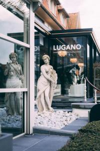 een standbeeld van een vrouw in een etalage bij Hotel Lugano in Knokke-Heist